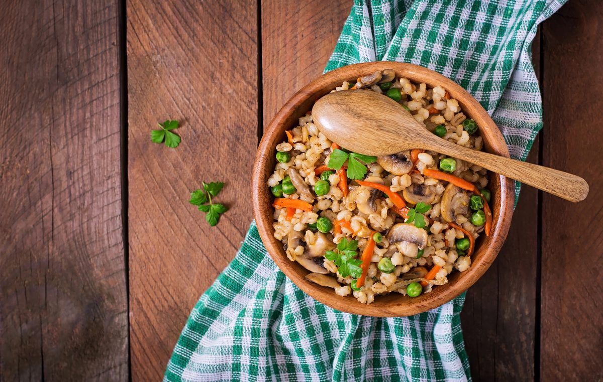 Kuba, pearl barley with mushrooms, in a wooden bowl
