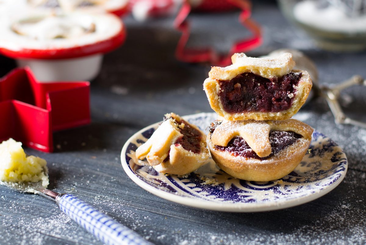 Homemade mince pies with a crumbly pastry top on a festive table