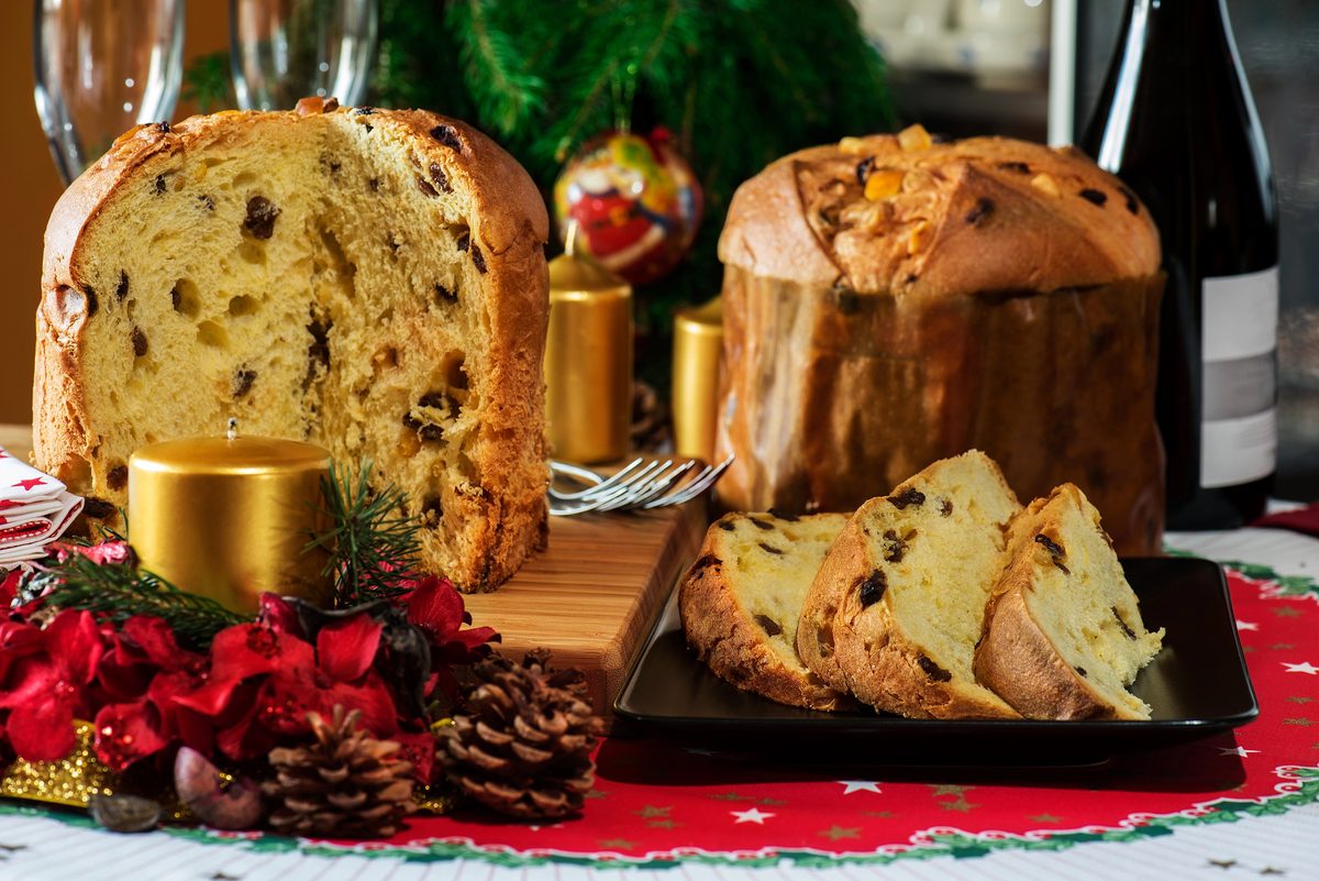 Panettone with candied fruit, whole and sliced, among Christmas decorations