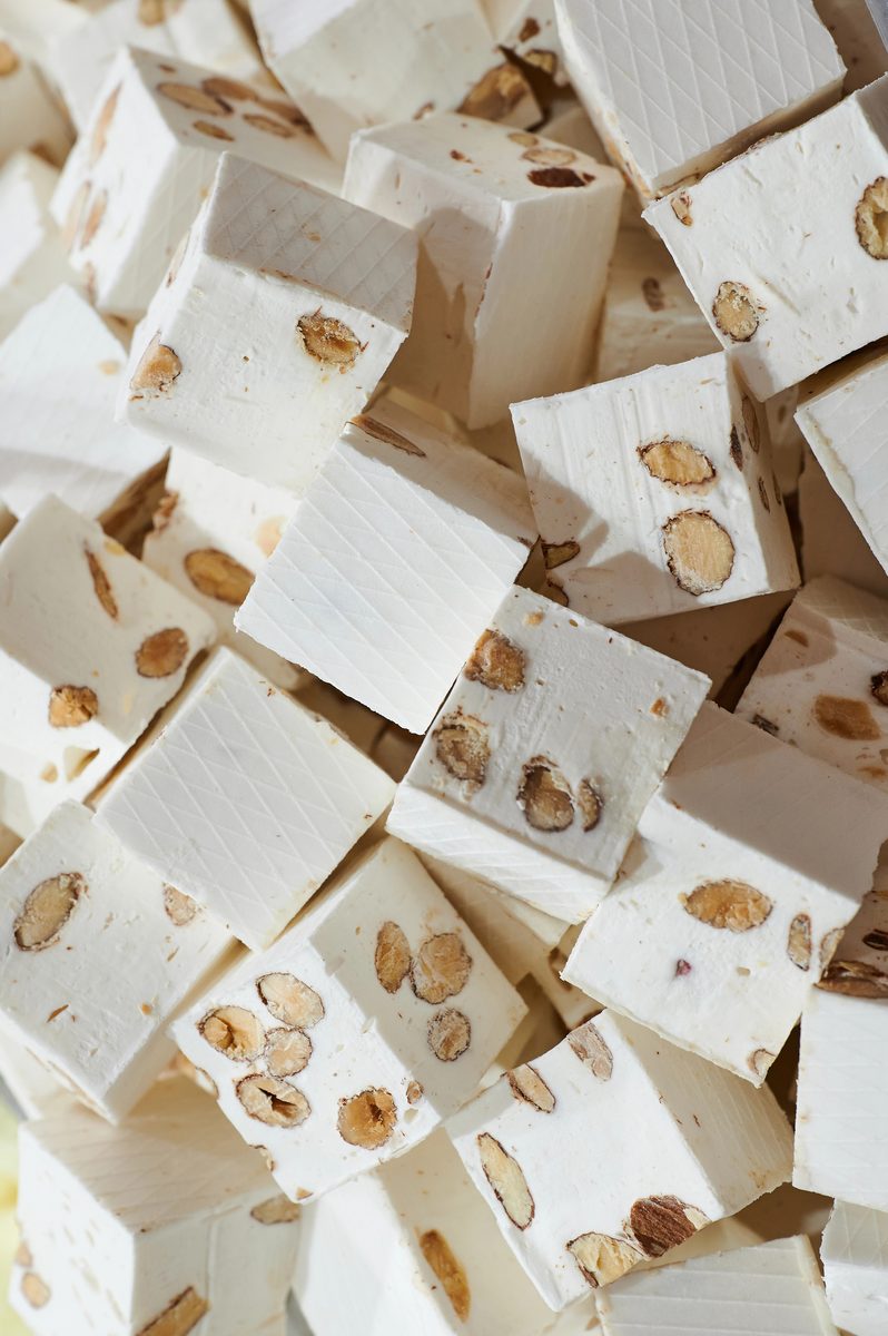 Pieces of white Italian torrone nougat studded with almonds