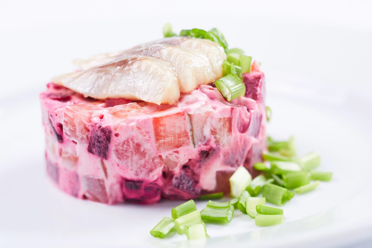 Swedish herring salad with beetroot, topped with herring and green onion