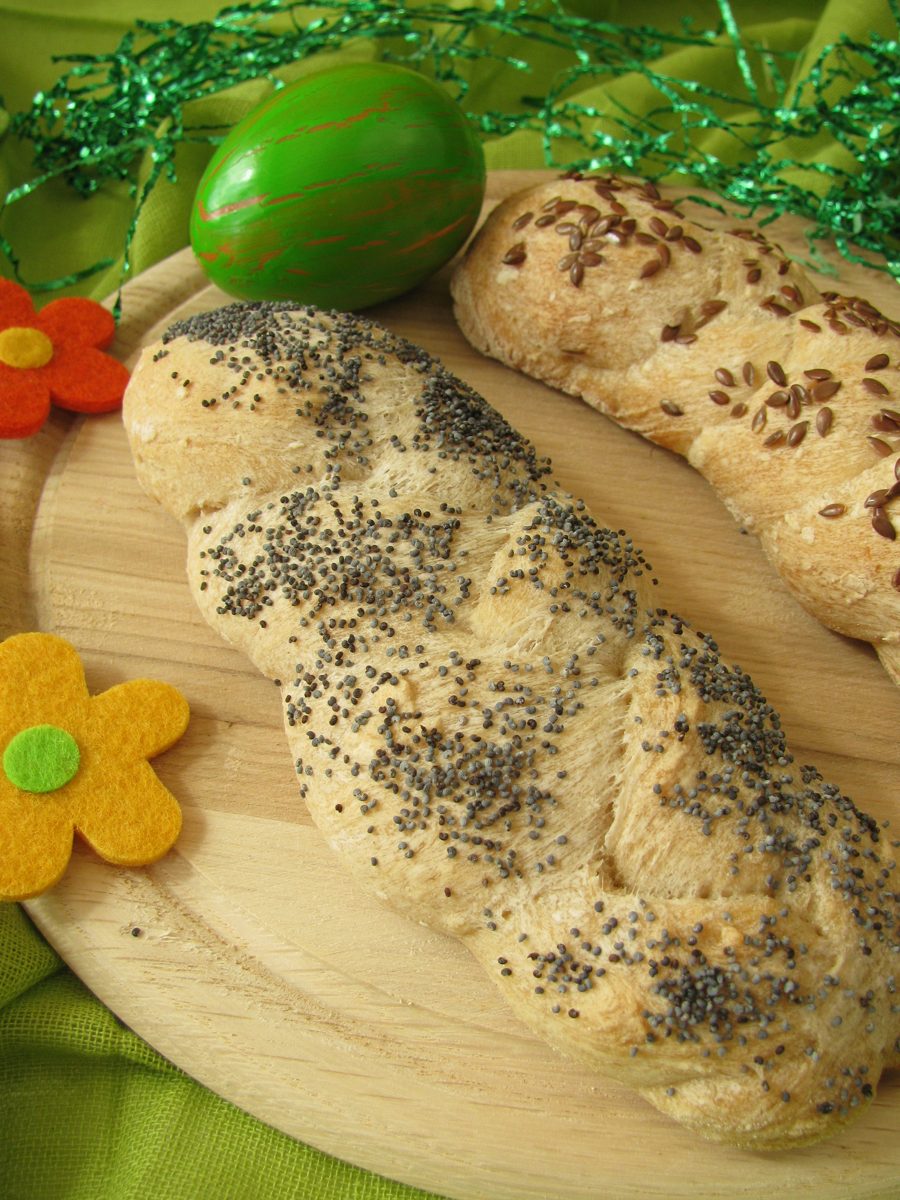 Braided Easter yeast loaves sprinkled with poppy seeds and Easter eggs
