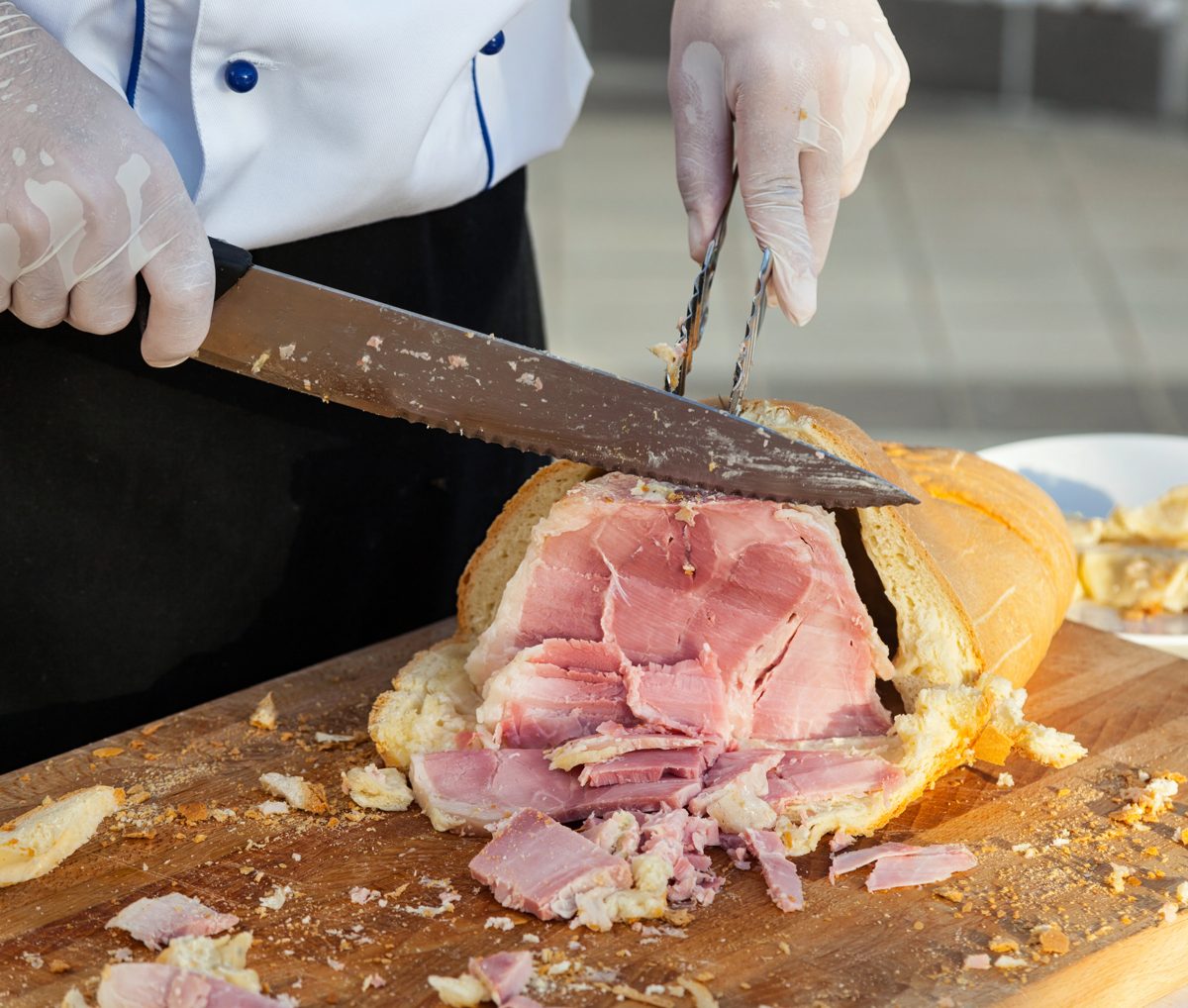 Ham baked in a bread crust being sliced on a cutting board