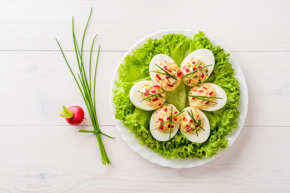 Stuffed eggs on lettuce garnished with chives