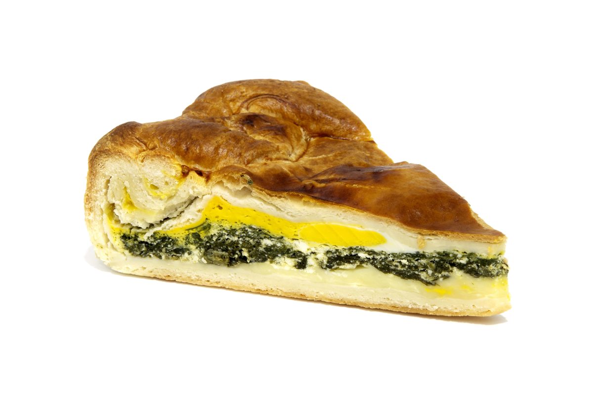 Slice of torta pasqualina, an Easter greens pie with a whole egg yolk inside