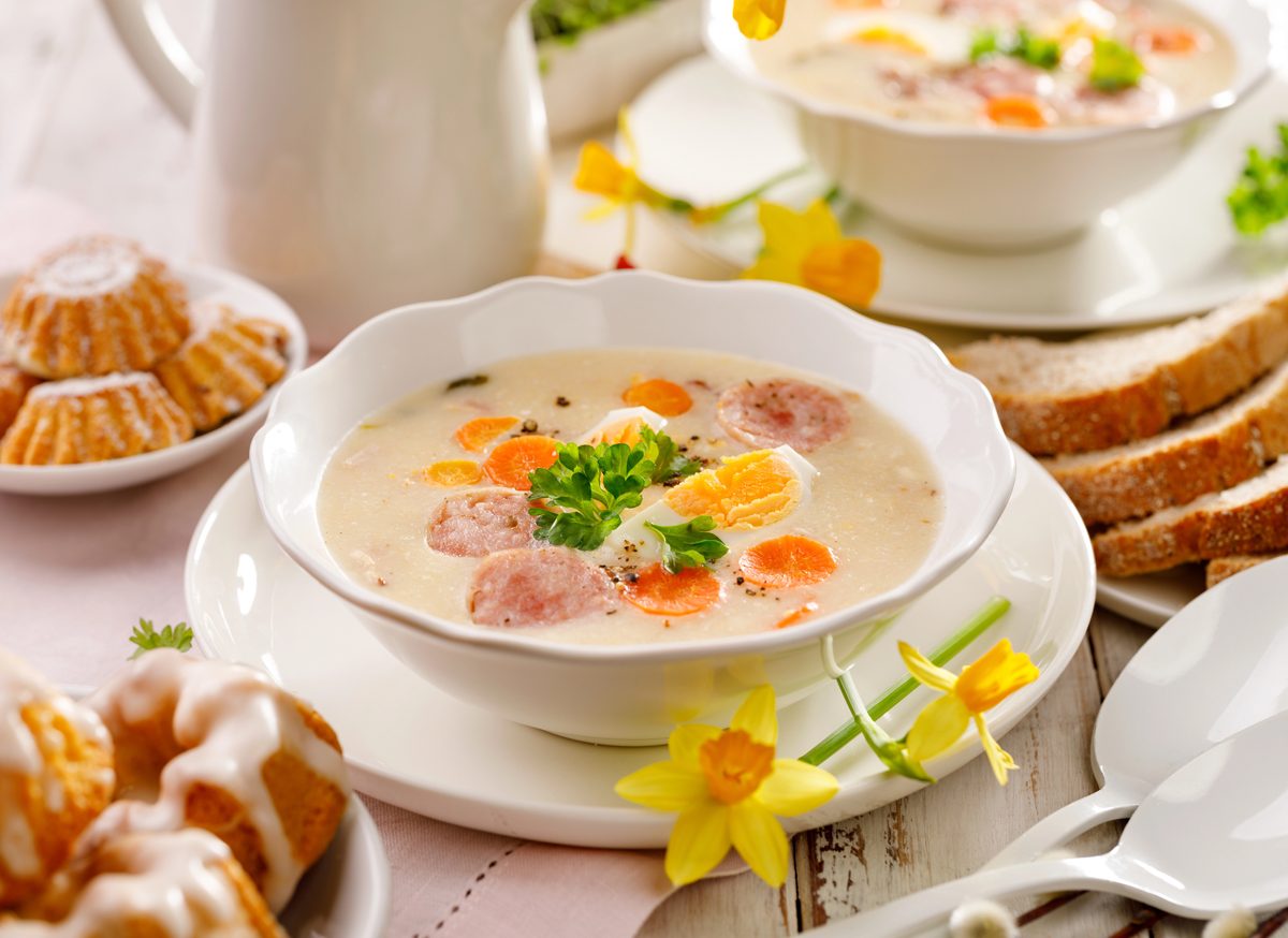 White borscht with sliced white sausage and egg on an Easter table