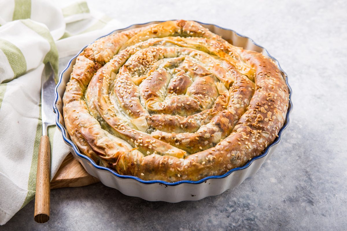 Spiral spring greens pie in a round baking dish