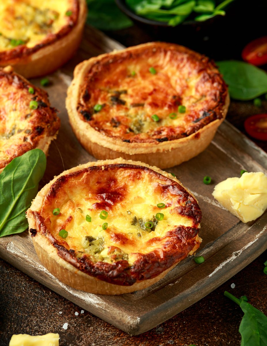 Cheese and egg tarts on a wooden board