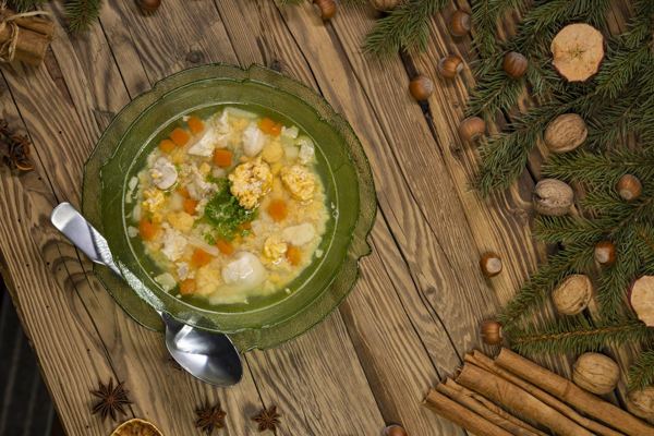 Czech Christmas fish soup in a green bowl on a wooden table