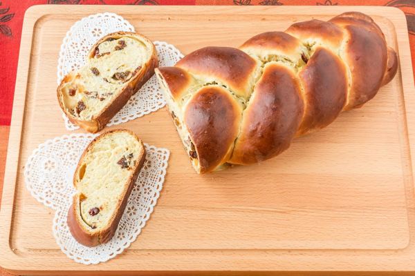 Braided vánočka sweet bread with raisins, sliced on a board