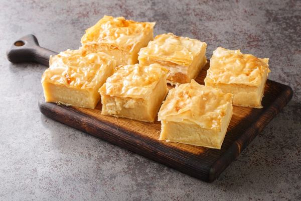 Squares of galaktoboureko, custard baked in filo pastry, on a board