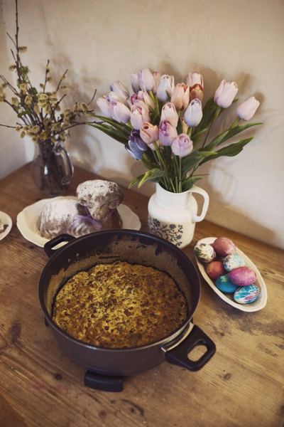 Czech Easter nádivka, a bread, meat and herb bake, in a cast-iron pan on an Easter table