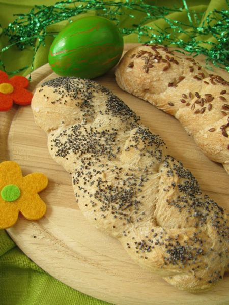 Braided Easter yeast loaves sprinkled with poppy seeds and Easter eggs