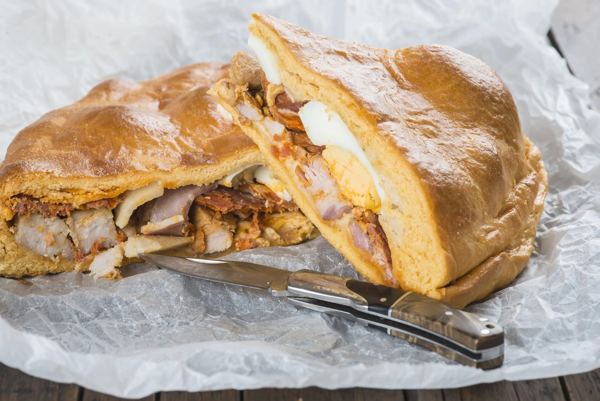 Hornazo, a Spanish bread pie filled with cured meats and egg, cut open