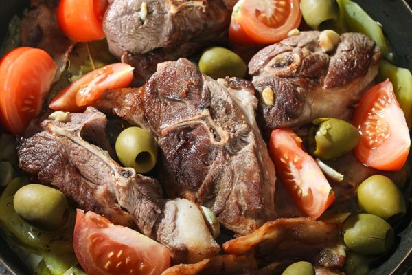 Roast lamb with potatoes, tomatoes and olives
