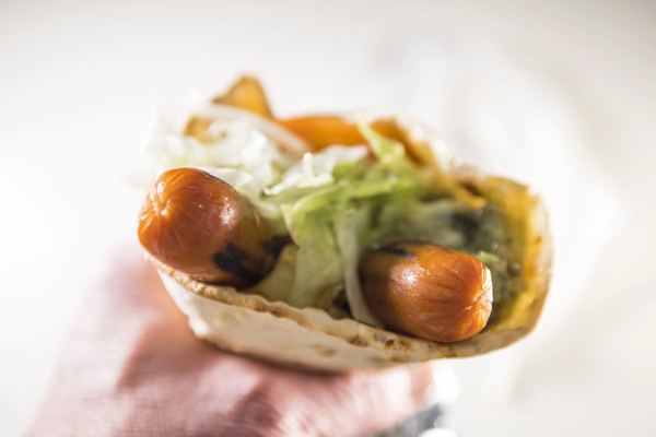 Sausages in a soft flatbread wrap with mashed potato and salad