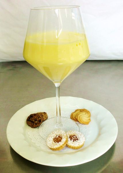 Egg cream dessert in a wine glass with cookies