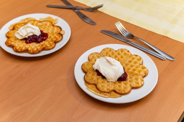 Heart-shaped Swedish waffles with jam and whipped cream