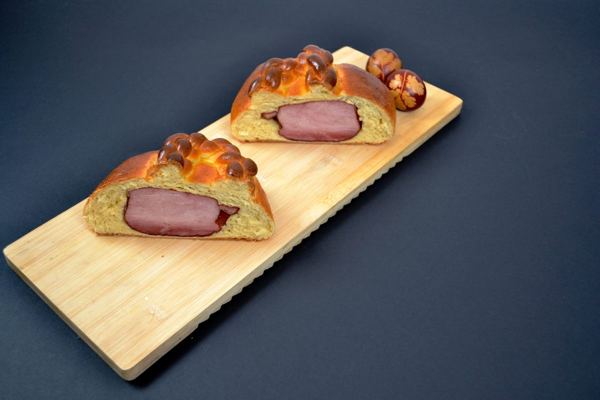 Ham baked in a golden bread dough on a wooden board