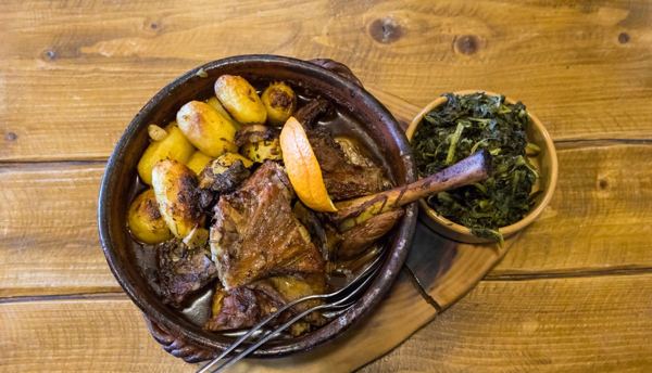 Roast kid goat with potatoes in a clay dish