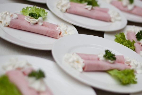 Ham rolls filled with horseradish cream on plates